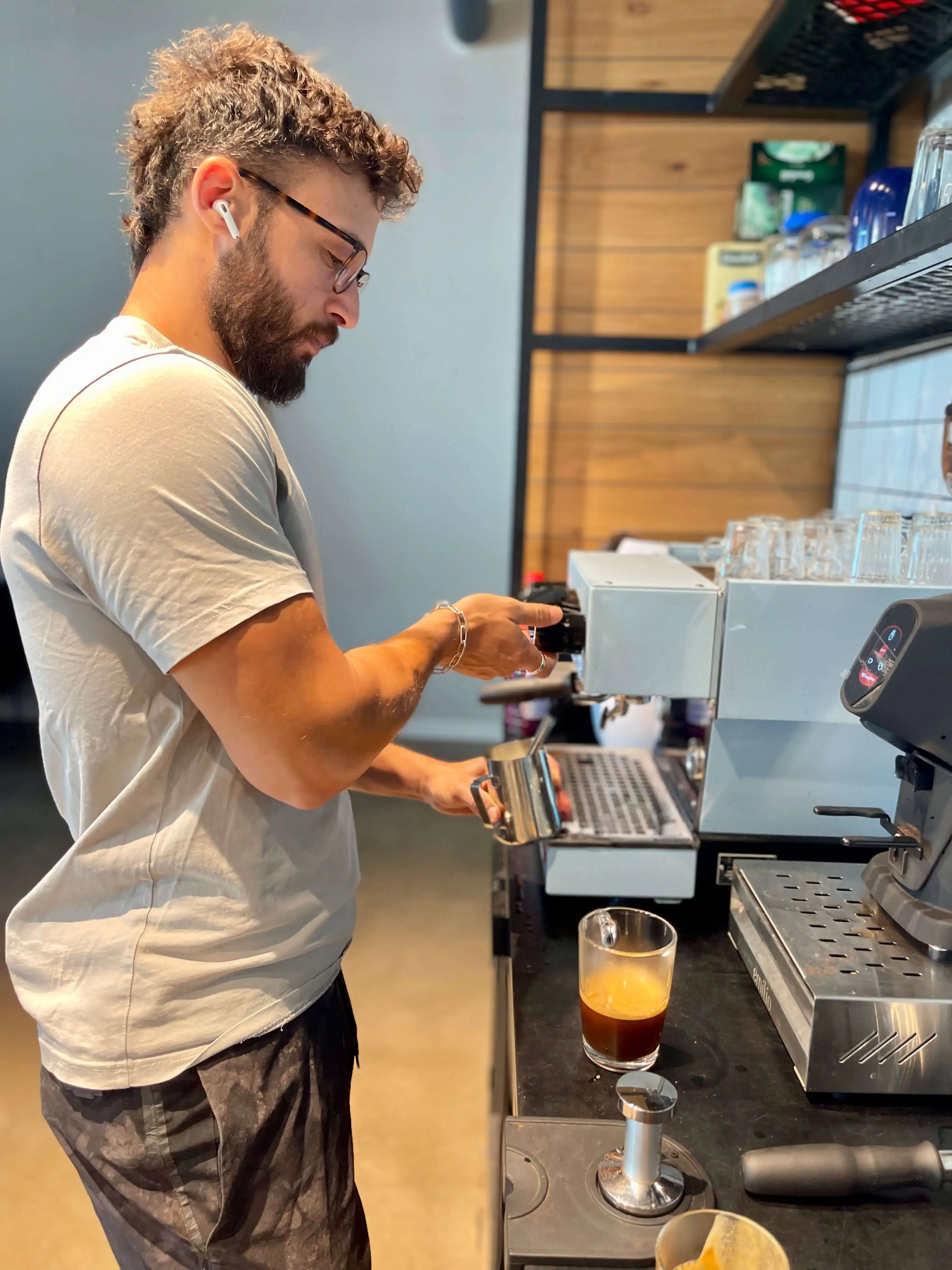 Two people watch as their co-worker skateboards in the office